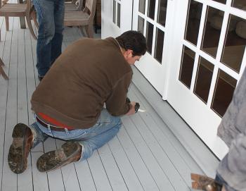 Kurt Drinkwater of Rockport cuts the first deck board to access his dog, Lucy, and the fox she chased late Monday morning. (Photo by Holly S. Edwards)