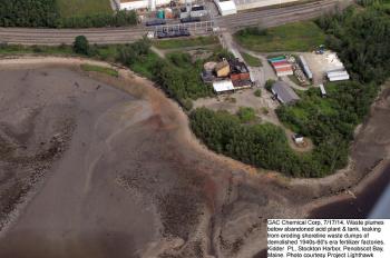 An aerial photograph of Kidder Point showing the abandoned sulfuric acid plant and a plume of discoloration apparently emanating from the shore nearby that environmental activists believe is acidifying the water and mud flats. (Photo courtesy of Project LightHawk)
