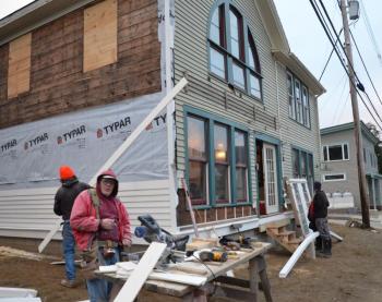 Rick Doherty and Daniel O’Connell get new clapboards onto 57 Bay View Street. (Photo by Lynda Clancy)
