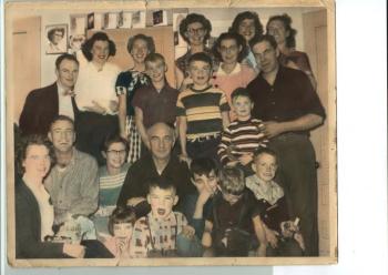 Russ and Jennie Carver surrounded by their children, their spouses and the grandchildren on a Christmas Day about 1950. See the cards taped around the door frame. Front row:Doris (Carver) Delano, Laurel (Rokes) Williams, John Delano, Phillip Tibbetts, Jack Carver, Norman Carver Jr. 2nd row:Norman (Pete) Carver Sr., Jennie (Hardy) Carver, James Russell Carver Sr.,Thomas Rokes 3rd row: Samuel Tibbetts Jr., Sanford R. Delano, Hope (Carver) Tibbetts, Sanford F. “Buster” Delano Back row: James Russell Carver Jr., Barbara (Barrett) Carver, Edith (Carver) Gallimore, Winnifred (Carver) Rokes/Marriner, Patricia (Tibbetts) Richardson, Eileen (Bishop) Carver. (Photo courtesy of Sandy Delano) carver farm christmas