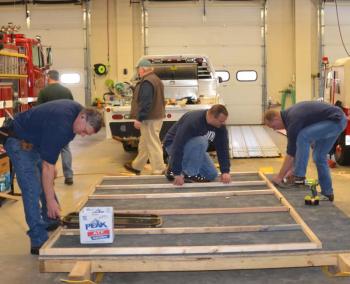 Phil Brown, Neal Bartley and John Wickenden get the shack framed. (Photo by Lynda Clancy)