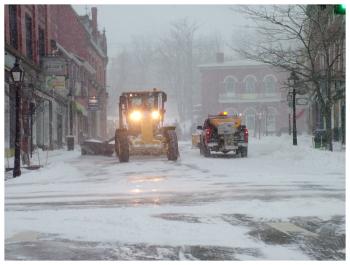 Two city plows pass on Main Street. (Photo by Ethan Andrews)