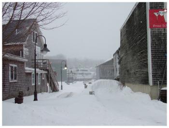 Through the snow, the view north from Marshall Wharf along the Belfast Harbor Walk frames a massive boat at Front Street Shipyard. (Photo by Ethan Andrews)
