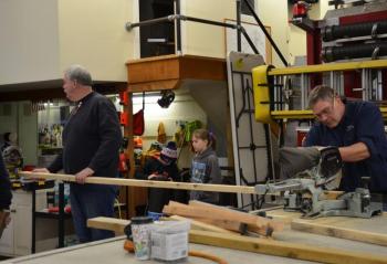 Rockport Police Chief Mark Kelley and Phil Brown get the boards sawed. (Photo by Lynda Clancy)