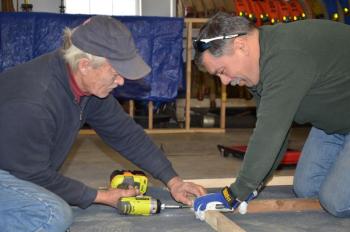 Rockport firefighters Michael Callaway and John Sylvester measure the framing for a new ice shack built for military veterans. (Photo by Lynda Clancy)