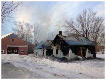 A wide view of the house at 109 Chandler Road that burned Monday night, and a barn, left, that didn’t on account of a long night put in by local firefighters. (Photo by Ethan Andrews)