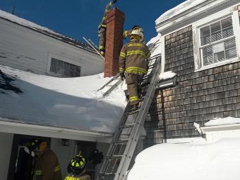Due to the arrangement of the Yarnell’s roof lines, and the chimney, an attic ladder had to be used to allow Lincolnville firefighters to get above the chimney opening to drop a chain down and dislodge burning creosote inside. (Courtesy Lincolnville Fire Department)