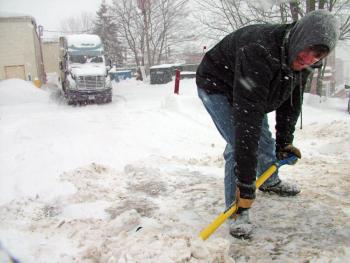 Evan Fletcher of Stockton Springs shovels a path for his delivery truck in Belfast during Monday’s snowstorm. (Photo by Ethan Andrews)