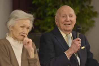 Linwood ‘Tick’ Thumm tells a joke to audience members at his 100-year birthday celebration alongside his wife Jane Thumm, March 26, 2015, at the Portsmouth Federal Building in Portsmouth, Va. Thumm was the commanding officer of an 83-foot Coast Guard cutter during World War II. (U.S. Coast Guard photo by Petty Officer 3rd Class David Weydert)