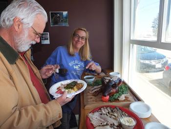 Rockland City Councilor Louise MacLellan-Ruf serves a slice of suckling pig to her husband ,Nick.