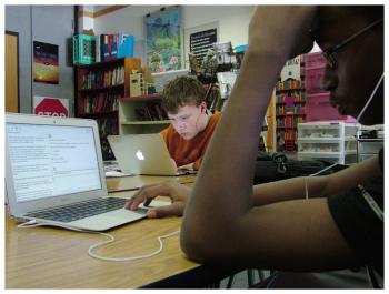 Eighth-graders Wyatt Ford, left, and Jared Anderson work on a practice version of the English Language Arts portion of the SBAC. (Photo by Ethan Andrews)