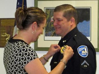 Rockland Police officer Joel Neal receives a new shield, from his wife, Heidi, denoting him as a detective for the department. (Courtesy Rockland Police Department)