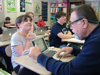 Shaylee Estabrook, left, lends her computer to Troy Howard Middle School math teacher Dennis Nardone, to review questions during a practice run of the state’s new standardized tests. (Photo by Ethan Andrews)
