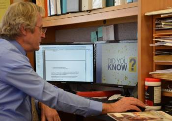 Rockport Town Manager Rick Bates at his office desk, where the hookup to fiber cable last year is now providing him with Internet download and upload speeds of 796 megabytes per second. (Photo by Lynda Clancy)
