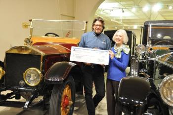 OHTM Executive Director Russ Rocknak receives a check for more than $125,000 from Dawn Swinton. Swinton's late uncle, Tom Appleton Plaisted, left the funds in trust for OHTM. Russ and Swinton elected to execute the check passing in front of the Museum's 1913 Rolls-Royce Silver Ghost which originally belonged to Plaisted's ancestor, Alice Longfellow.