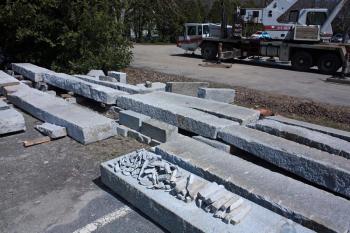 Granite slabs, being leveled by hand by Ron Hawkins, will eventually sit atop a new concrete foundation, with the historic barn that dates back 200 years or more on top of that. The barn will serve as an auxilliary building for Mahogany Salon at 63 Elm. St. (Photo by Holly S. Edwards)