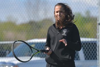 Lincoln Academy’s Cristina Garcia battles the wind as it howls through the courts. The wind and the sudden cold had it’s effects on both teams. (Photo by Ron Hawkes)