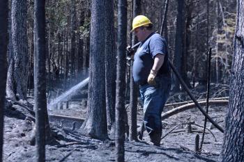 Firefighters from Liberty, Montville and Morrill joined Searsmont early Thursday evening to battle a woods fire off Choate and Jackson roads in Searsmont, while 56 volunteers from more towns across Knox and Waldo counties joined the continued effort Friday. Pictured is Hank Lang of Northport and Lincolnville fire departments. (Photo by Holly S. Edwards)