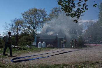 A fire at 40 John St. in Camden Thursday afternoon caused damage to an exterior wall and inside in the kitchen, both at the back of the home that sits close to the road. (Photo by Holly S. Edwards)