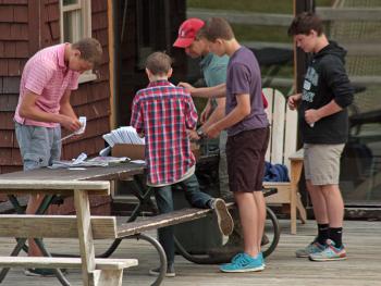 CRMS eight-grade student open the seed packets on the deck of the Snow Bowl lodge Thursday morning. (Photo by Holly S. Edwards)