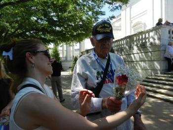 An unidentified teenager gives flowers to Maine veteran Ken Baker at Tomb of the Unknown Soldier at Arlington National Cemetery.