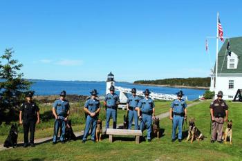 Pictured from left are Officer Jamie Fanning & K9 Aki, Trooper Barry Meserve & K9 Doyle, Trooper Jeffrey Taylor & K9 Oscar, Corporal Seth Edwards, Sergeant Scott Dalton & K9 Haro. Trooper Adam Schmidt & K9 Ibo, Trooper Andrew Levesque & K9 Vitz, Deputy Merl Reed & K9 Frankie. (Photo courtesy Maine Department of Public Safety)