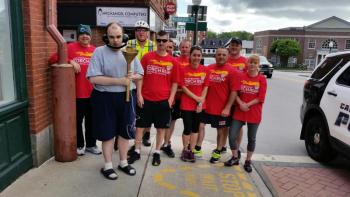 Graham Wiley, holding the torch, gathers with the runners in front of the Camden Town Office, just before he leads off the 2015 Torch Run for Special Olympics. (Photo by Sarah Shepherd)
