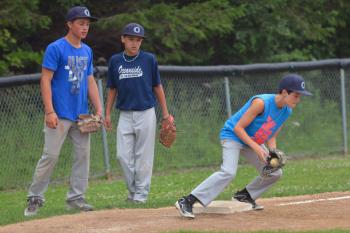 The first drill the boys works on was making the throw to the base and getting the tag down quickly. Here Logan Putansu come up throwing as Obie Miller and Nathan Coombs look on. (Photo by Ron Hawkes)