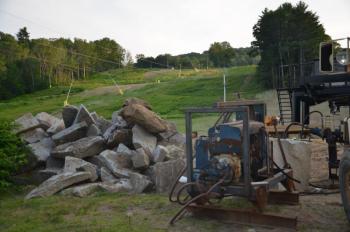 The old granite blocks came from an old wharf at the harbor, and now will be used to create a sloped wall around the chairlift at the bottom of Ragged Mountain. (Photo by Lynda Clancy)