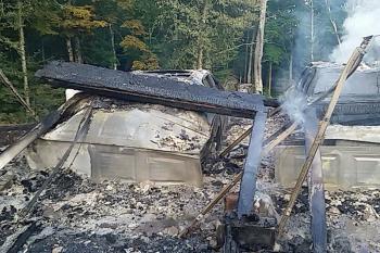 The metal frames of two vehicles are covered by rubble after the fire. (Courtesy photo)