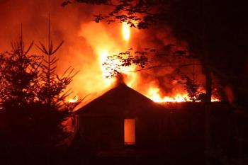 By the time firefighters were on scene and working the fire, it had consumed the residence, along with the attached garage, and could be seen burning through what had been the roof of the home. (Photo by Holly S. Edwards)