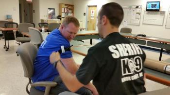 Rockland Police Sgt. Ken Smith volunteers for Deputy Jeremy Joslyn to practice applying a combat application tourniquet. (Photo by Sarah Shepherd)