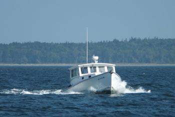 A lobster boat cuts across our bow.