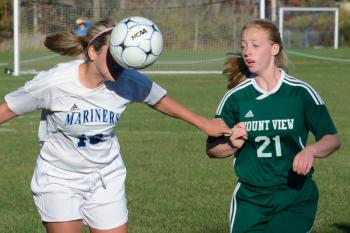 Oceanside’s Casey Jo Pine, left, gets a head on the ball as she attacks the goal as Mount Views Kristen Raven looks on. (Photo by Ron Hawkes)