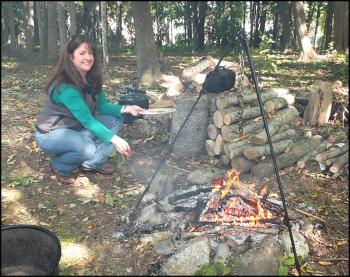 Heather Moran cooks maple marinated pepperoni on a stick over an open fire.