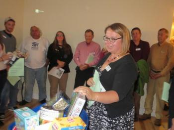 Mandie Sawyer, Executive Director of Habitat for Humanity of Waldo County, speaks to attendees before presenting the family with a gift basket. (photo by Erica Thoms)