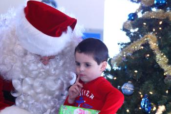 Some of the Coast Guard children knew exactly what they wanted for Christmas when they saw the Flying Santa Sunday at the Maine Lighthouse Museum, and they knew what it cost and where to get it. Others, had to think a little bit... (Photo by Holly S. Edwards)