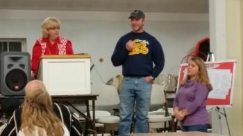 David Leighton, with his wife Lisa, addresses the room full of supporters at his benefit dinner, held in October. Linda Payson, left, lead the crowd in the live auction. (Photo by Sarah Shepherd)