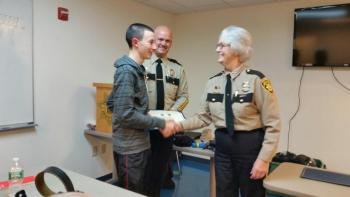 Trevor Carty receives his diploma from Sheriff Donna Dennison and Chief Deputy Tim Carroll. (Photo by Sarah Shepherd)