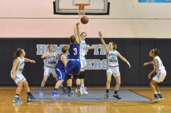 Oceanside’s Elise Laslavic, back center, tells Morse’s Maddy Mitchell not in my house as she swats the ball away on the shot. (Photo by Ron Hawkes)
