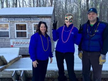 Getting into the Mardi Gras spirit and checking the chute in preparation for the 2016 U.S. National Toboggan Championships are, from left, June Parent, executive vice president and senior retail banking officer for Camden National Bank; Jody Landrith, Camden Main Office branch manager; and Andrew Dailey, Toboggan Committee member.