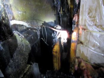 Wiring for an electrical switch, and the bit of wire and a nail used to hold it up above the stove pipe, actually acted as a heat conductor to exacerbate the problem that caused the wall to catch fire. (Courtesy Rockport Fire Department)