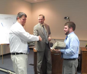 Councilor Will Clayton with Coach assistant coaches coaches Darren Randall and Larry Reed receive a gift to build a foundation.