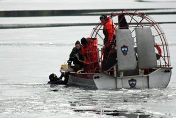 A Maine Warden Service diver slips into Megunticook Lake, about 150-feet off Wiley Neck in Lincolnville, Tuesday morning to search for the body of 20-year-old Trueman Moore of Camden. (Photo by Holly Edwards)