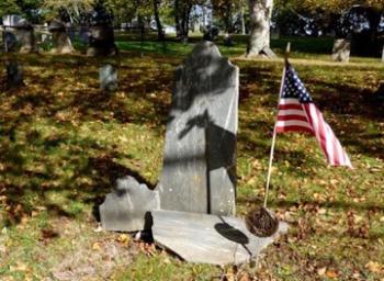 Kate Marshall, (not shown) of Nevada, came to Tolman Cemetery to view her Patriot ancestor’s grave. She found the gravestone of Benjamin Blackington (1749-1812) in several pieces, broken away from the double headstone with his wife, Eunice Woodcock (1743-1815). The image by Carl Mahoney shows the stone awaiting restoration and reuniting.