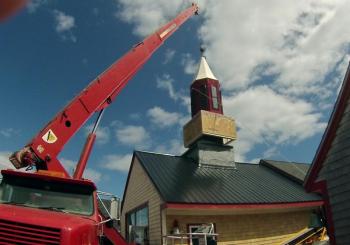 From the ground to the top of the building, a new steeple gets set into place.