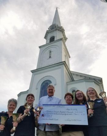 Members of Penobscot Bay Ringers, from left, including Ann Walker, Leigh Smith, Amy Rollins, Grace Jameson and Michelle Terry, present a ceremonial "big check" to Jeff Foltz, chairman of the Save our Steeple committee. (Not present: Susan Barnard, Debra Hall, Susan Jones, BJ Kopishke, Buffy Ludwick, Evelyn O'Connell, Fran Pan and Cindy Schofield.)