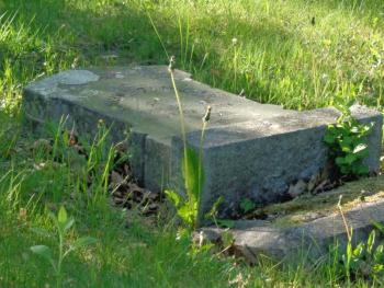 A headstone lies flat against the earth at Rockland’s Tolman Cemetery. (Photo by Sarah Thompson)