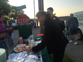 With a Sheepscot River sunrise in the background, Susan Robson of Sarah’s Cafe tends a snack table. SUSAN JOHNS/Wiscasset Newspaper
