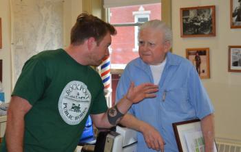 Rockport Select Board member Owen Casas shares a joke with Roger Jones, June 7, at the Jones Brothers barber shop. (Photo by Lynda Clancy)